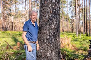 Rufus Duncan stands next to a tree.
