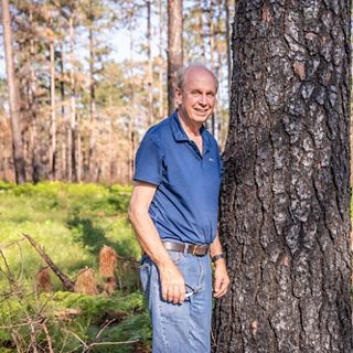 Rufus Duncan stands next to a tree.