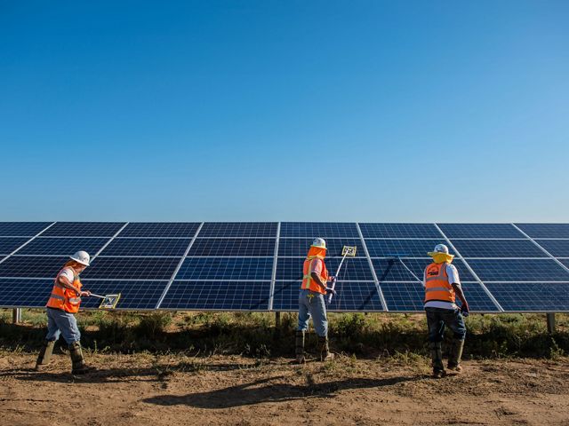 Worker's clean solar panels for maximum efficiency at the power solar facility in Lancaster, California.