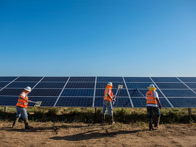 Workers clean solar panels for maximum efficiency at the power solar facility in Lancaster, California.   