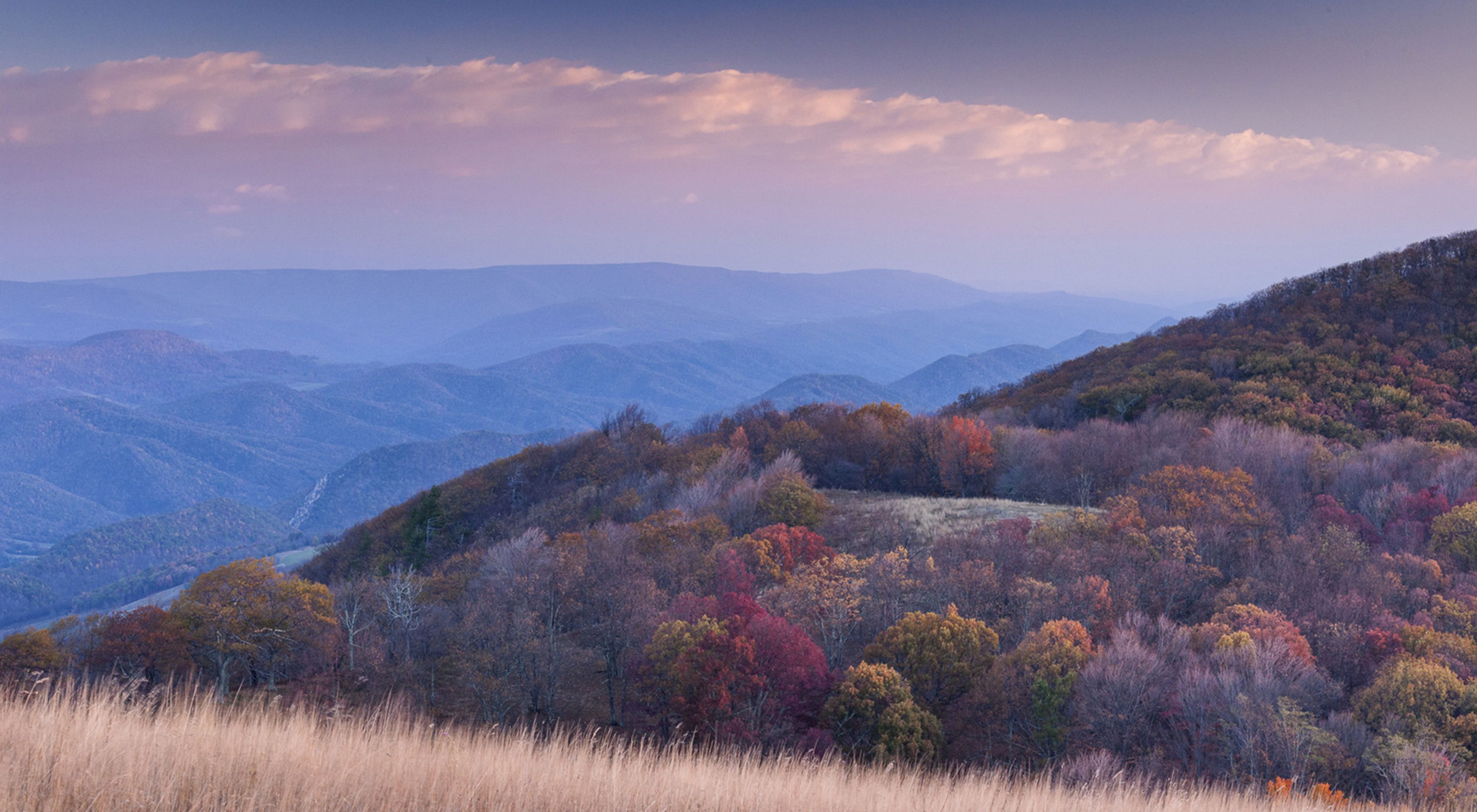 View overlooking a vast mountain range in autumn colors.