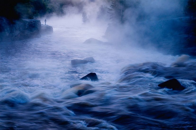 Fly fishing in early morning mist near the famous rafting spot called "crib works", on the East Branch of the Penobsot River just upriver of Mount Katahdin in Maine.