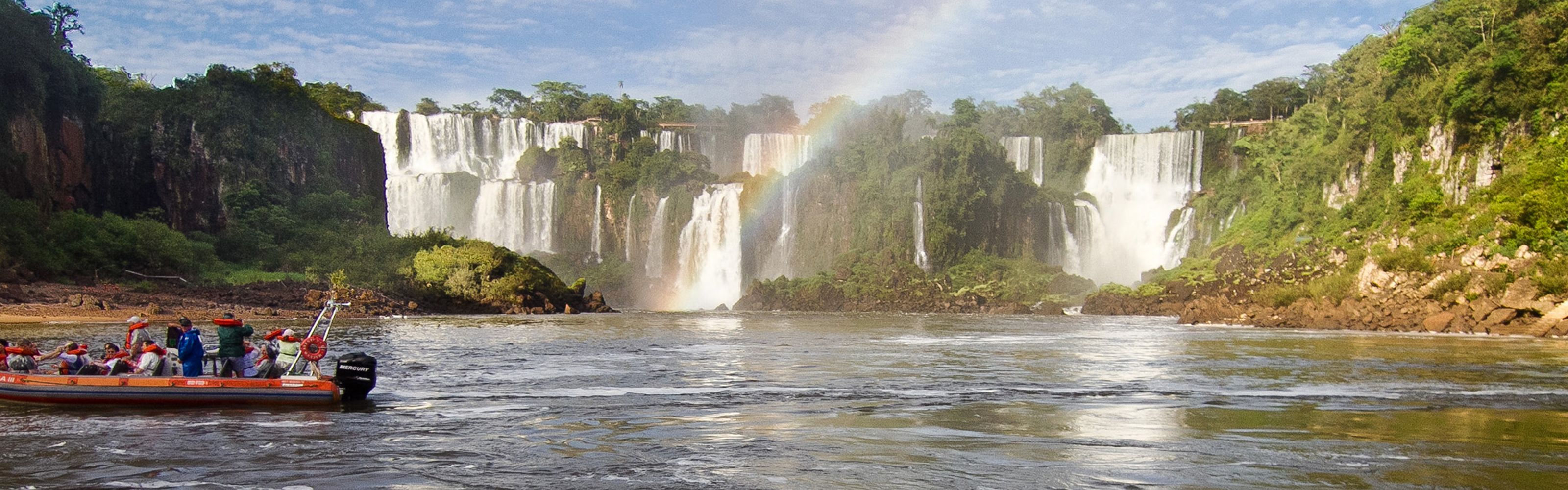 Tourists sit in a red motor boat at the based of Iguaçu