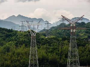 View of high voltage power lines on a mountain range.