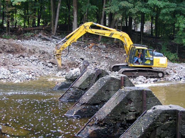 Construction equipment removing a dam.