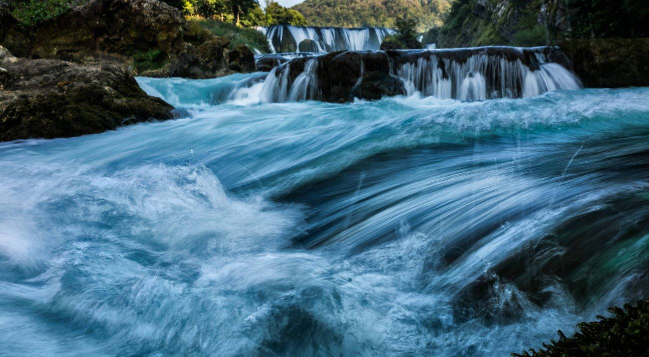 Rapidly flowing water going down waterfalls in the Una River.