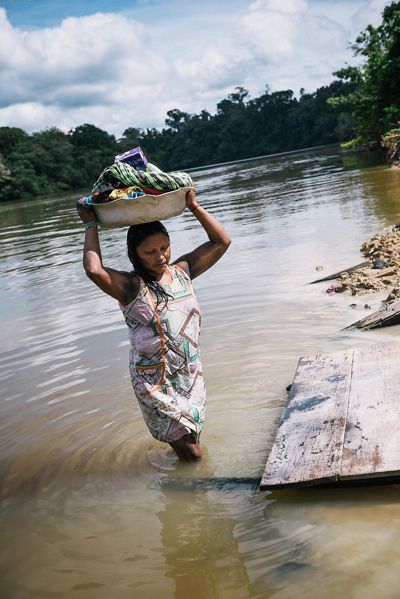 A Xikrin woman in the Pot-Kro Village carries items washed in the river. 