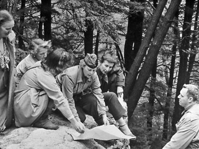 Black and white photo of a group of people in the forest.