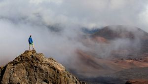 A TNC staffer stands on a rock inside the creater of Haleakala National Park, Maui, Hawaii. 