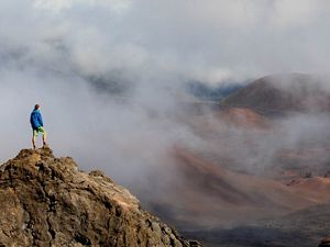 A TNC staffer stands on a rock inside the creater of Haleakala National Park, Maui, Hawaii. 