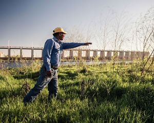 Juan Butron examines new willow saplings that have shot up since the Pulse Flow event in the Spring of 2014. The Morelos dam behind him marks the border between the USA and Mexico and diverts 1.55 million acre feet of the Colorado River into Mexican irrigation canals, supplying water to farmers in the Mexicali Valley as well as to the municipalities of Mexicali, Tijuana and Tecate.