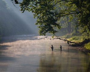 Dos pescadores dentro de un río