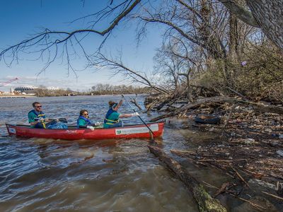 people in a canoe near a city