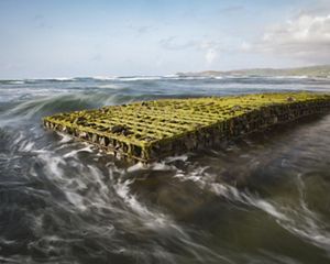 Steel cages filled with rock and concrete form a reef