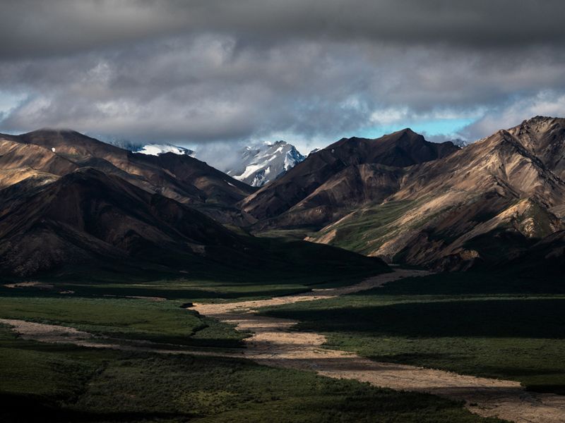 Dramatic view of a mountain pass under dark clouds in Alaska.