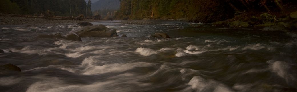Time-lapse image of a rushing river running over rocks and boulders.