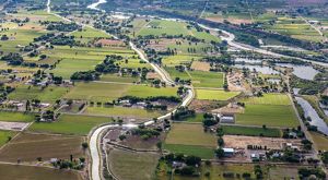An aerial image of agricultural fields and plots intersected by a river.