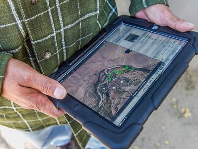 Gary Jordan, of Keller-Bliesner Engineering, uses a tablet to identify potential restoration sites along the San Juan River near Shiprock, New Mexico.