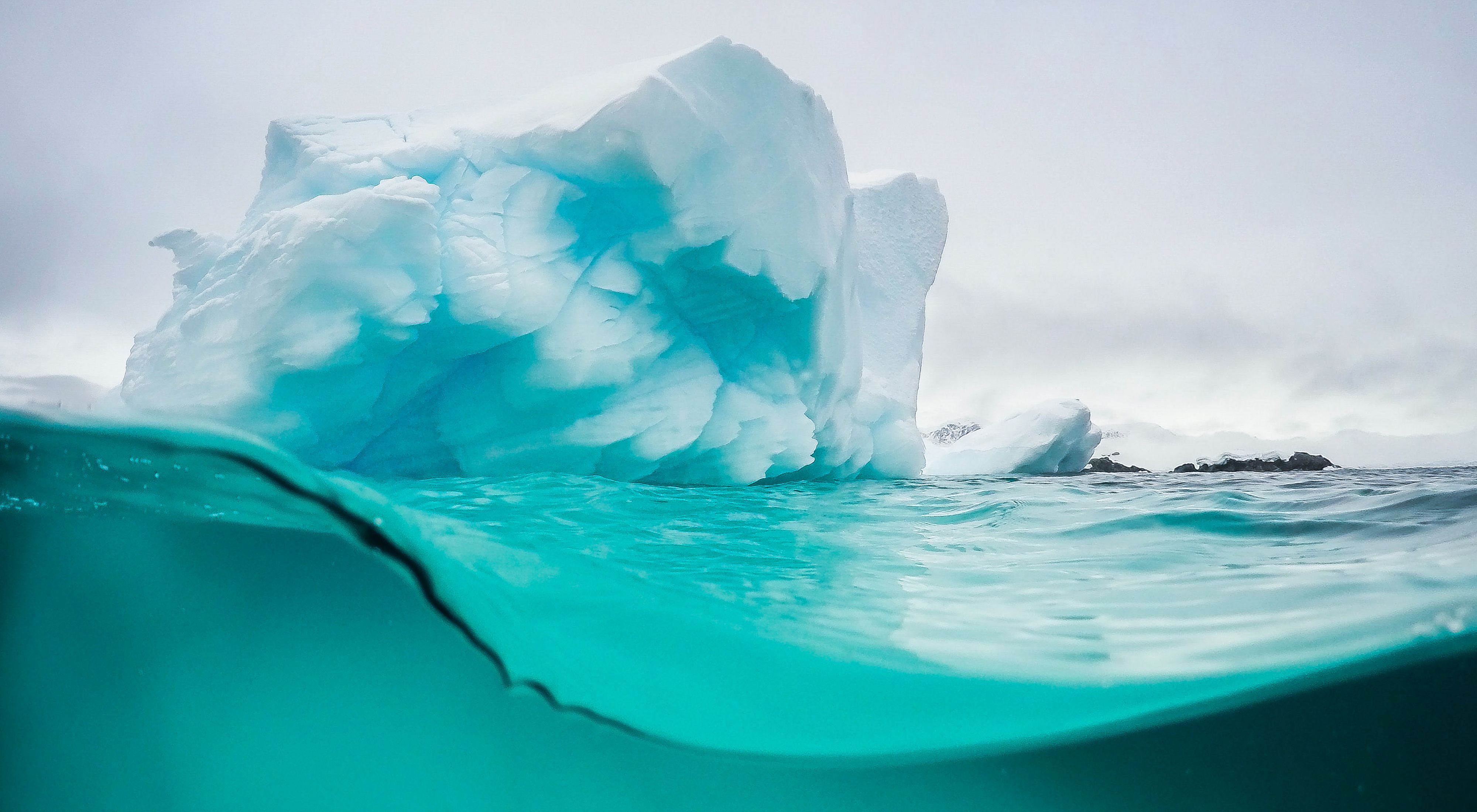 Vista por debajo y por encima de la superficie de un iceberg en la Antártida