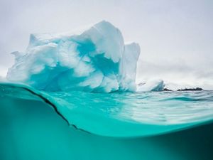 Vista por debajo y por encima de la superficie de un glaciar en la Antártida.