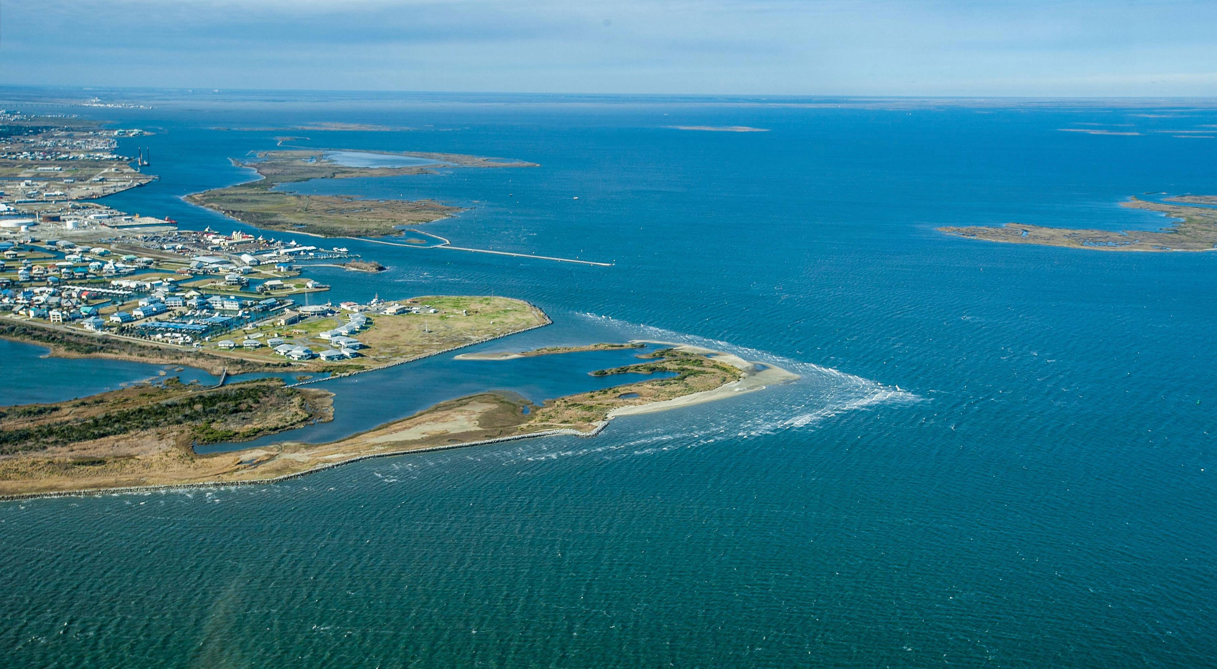 Aerial view of the ocean and towns and buildings along the coast of Grand Isle.