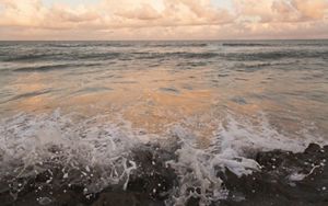 Closeup of surf crashing onto a beach.