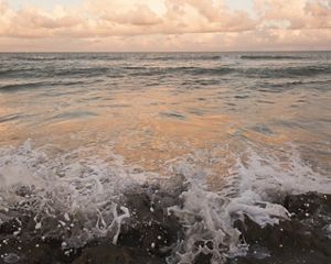 Closeup of surf crashing onto a beach.