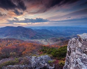Mirador con vistas del follaje otoñal, una montaña y un valle.