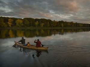 Canoe paddlers cross a quiet Penobscot River.