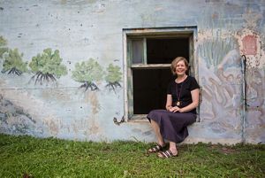 Robyn James sits in windowframe of stone building