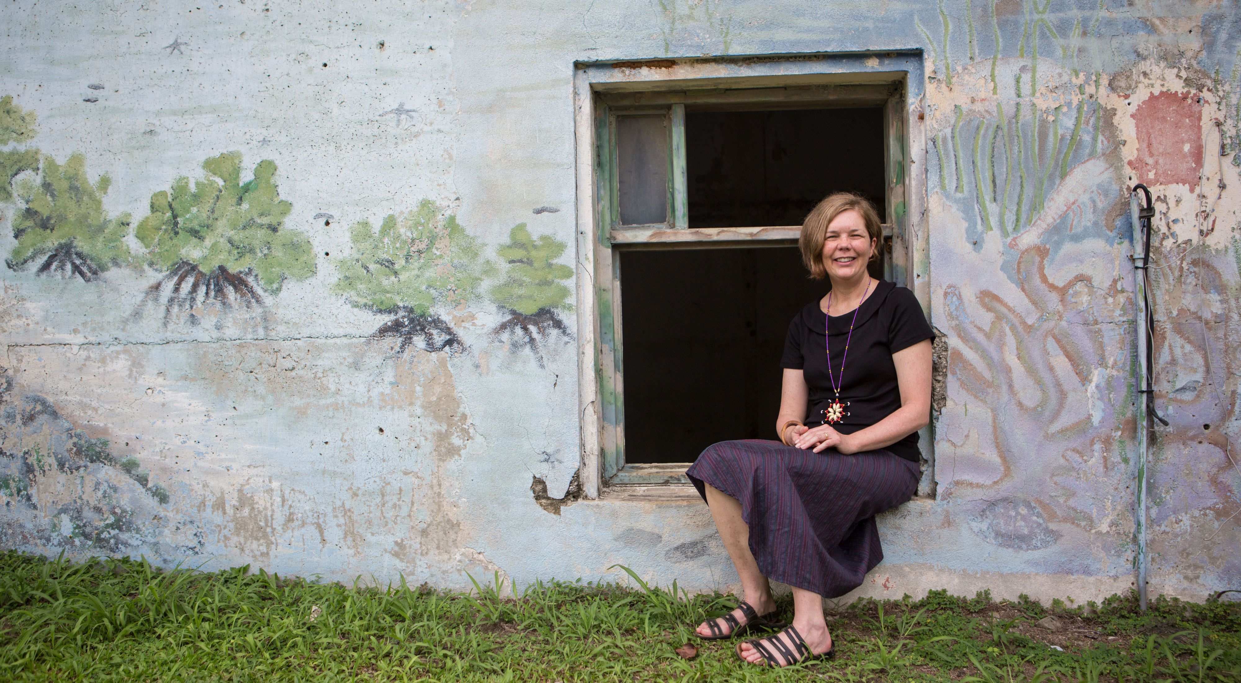 Robyn James sits in windowframe of stone building