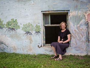 Robyn James sits in windowframe of stone building