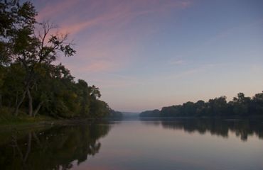 A view of the flat Wabash River during sunset.