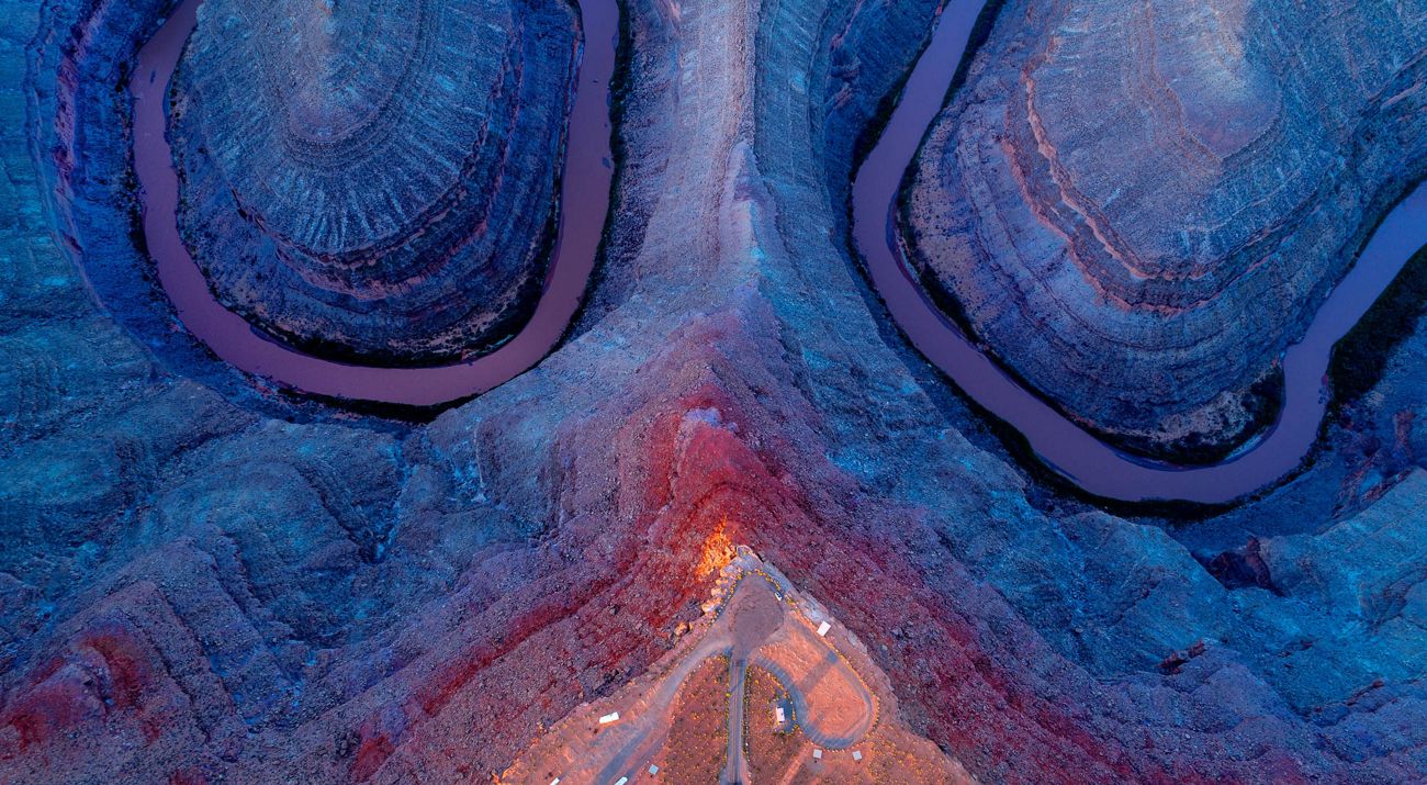 Aerial view looking straight down on a winding river that meanders through rocky landforms.