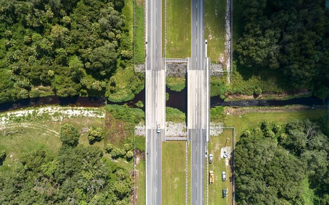 An aerial photo of State Road 80 near LaBelle, Florida. Beneath the bridge in the photo is a wildlife underpass that is used for safe passage by a variety of wildlife. TNC Florida worked with the Florida Department of Transportation to establish this underpass that connects land easements on both sides of the road and establishes a path for animals to travel. May 2019.