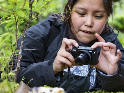 A girl takes a photo as part of a photography workshop