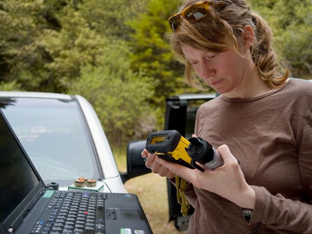 Jennifer Carah, una científica de ciencia aplicada del equipo de The Nature Conservancy California, checando unos dispositivos de registro que usa para registrar y obtener datos de temperatura del agua.