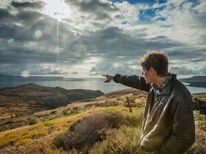 A man points out toward the ocean at the western edge of Santa Cruz Island.