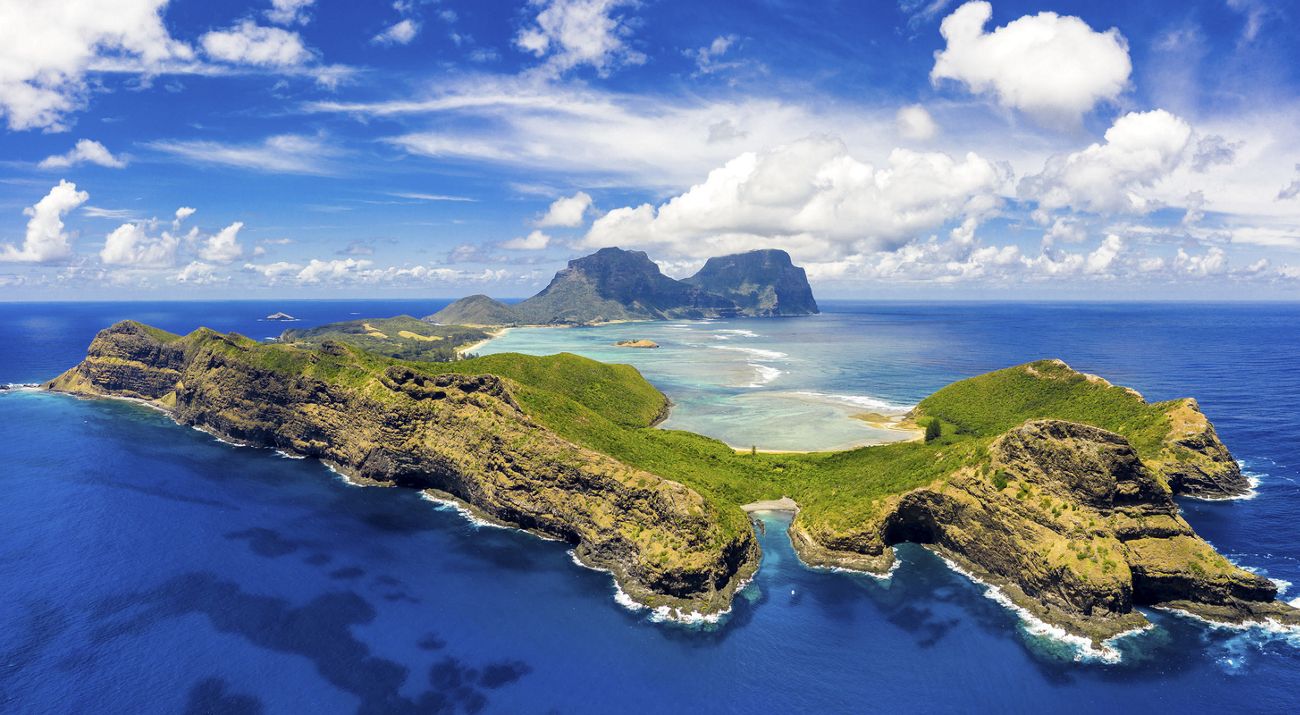 An aerial view of a mountainous island surrounded by blue water.