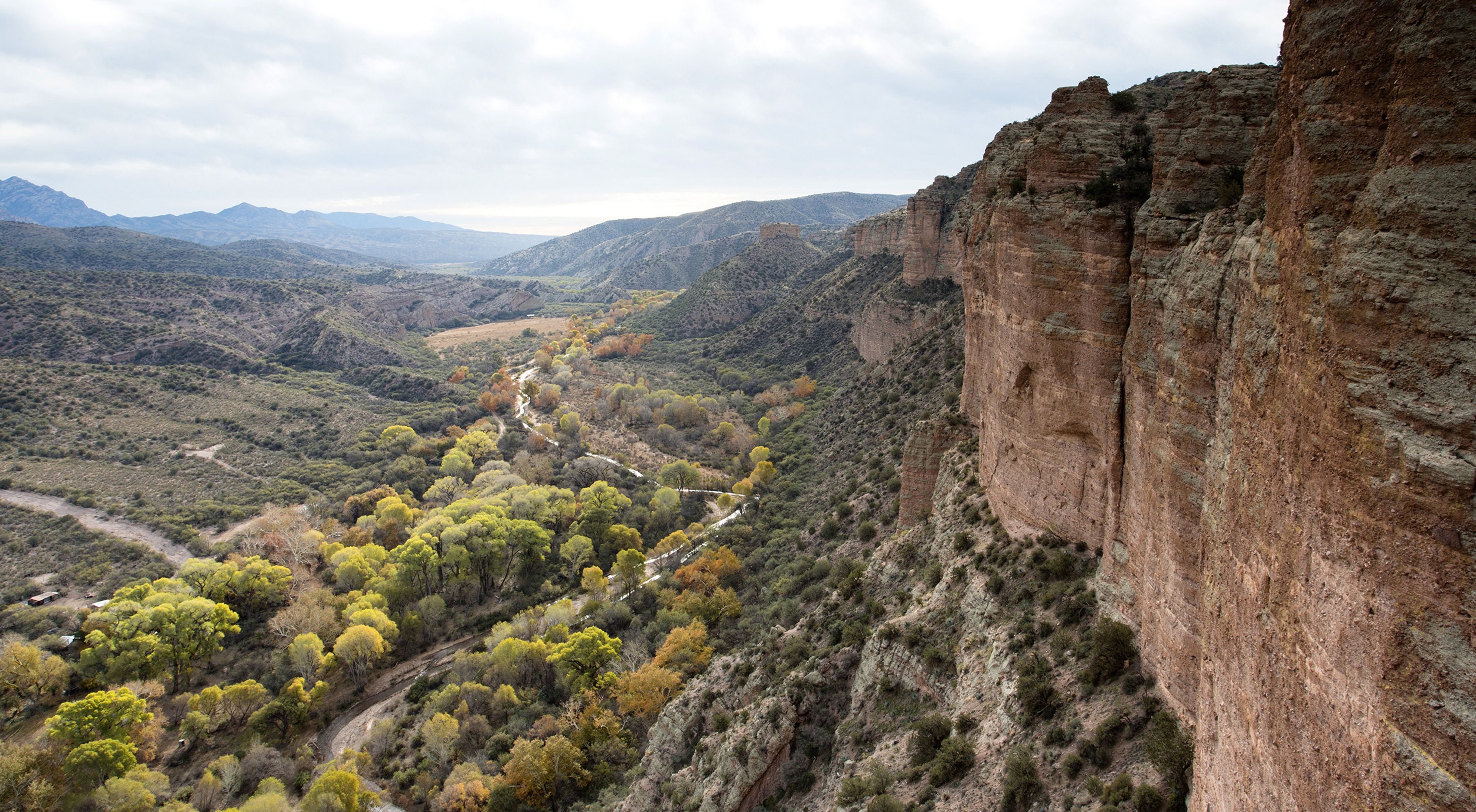 A landscape view of a valley, with steep red canyon wal