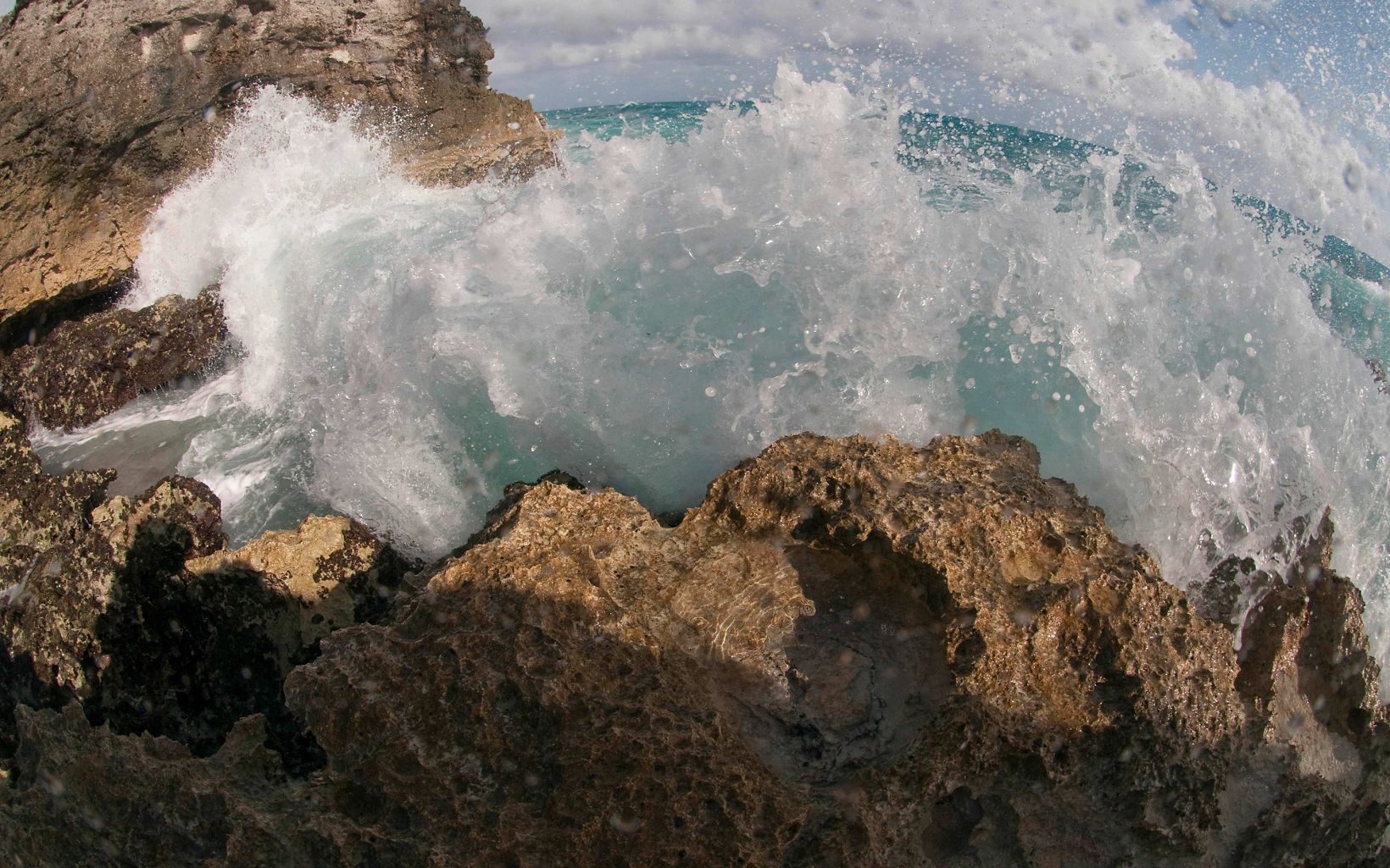 Water splashes against the rocky shore.
