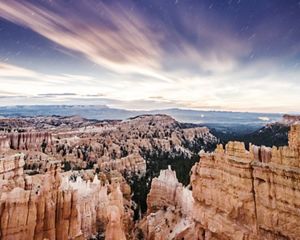 Landscape view looking across a vast chasm with large cliffs and rock formations in Bryce Canyon, Utah.