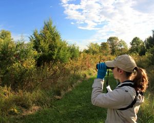 A woman with binoculars enjoys a morning bird walk.