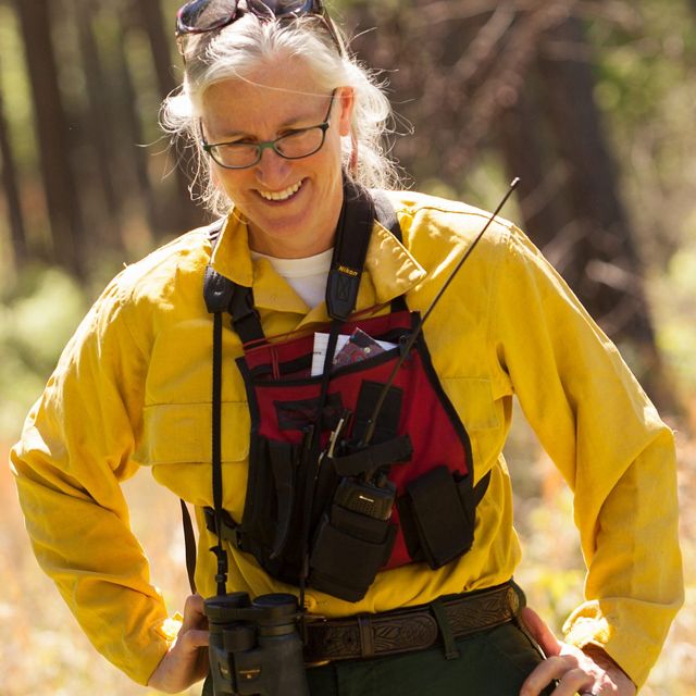 A candid photo of a woman wearing yellow fire gear.
