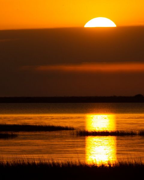 Sun sets at Powderhorn Ranch, one of the few remaining large tracts of intact native coastal prairie and wetlands on the Texas coast.