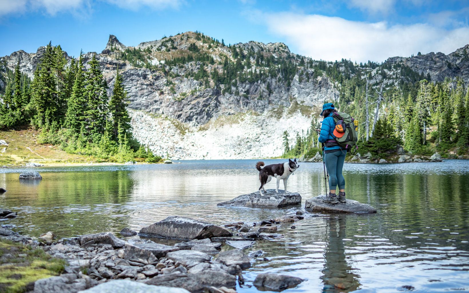 A hiker and a dog at Minotaur Lake in the Cascades Mountain Range in Washington state.