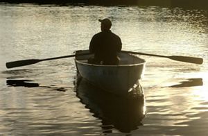 Three children paddle down a river in a canoe.