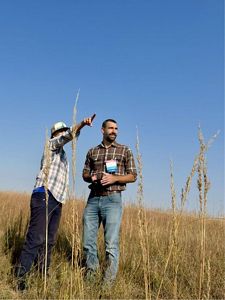 Two men look across a vast prairie.