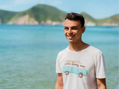 Tomás Pinzón se encuentra afuera frente a un gran cuerpo de agua.