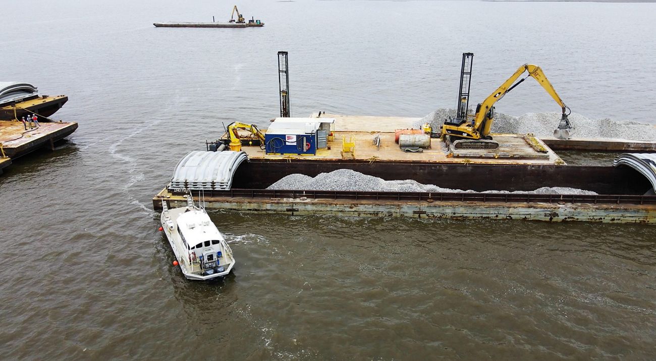 A large flat boat floats in calm waters.